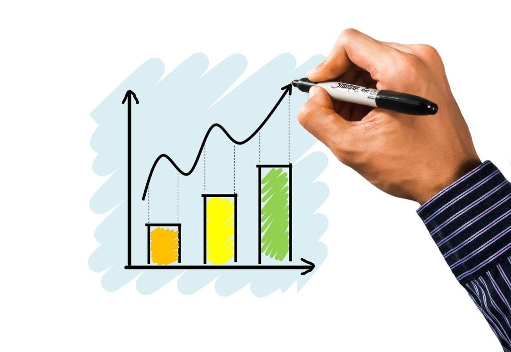 Trainee arbeitet aan data analytics projecten met laptop en data visualisaties op het scherm