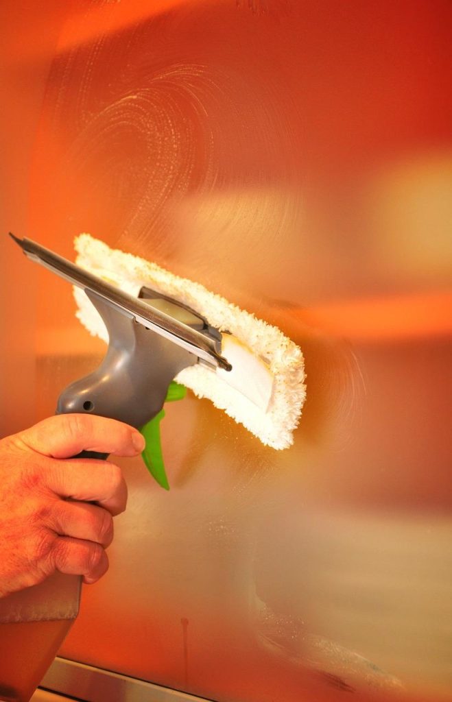Professionele glazenwasser in Den Bosch schoonmaakt ramen streeploos schoon van een historisch gebouw